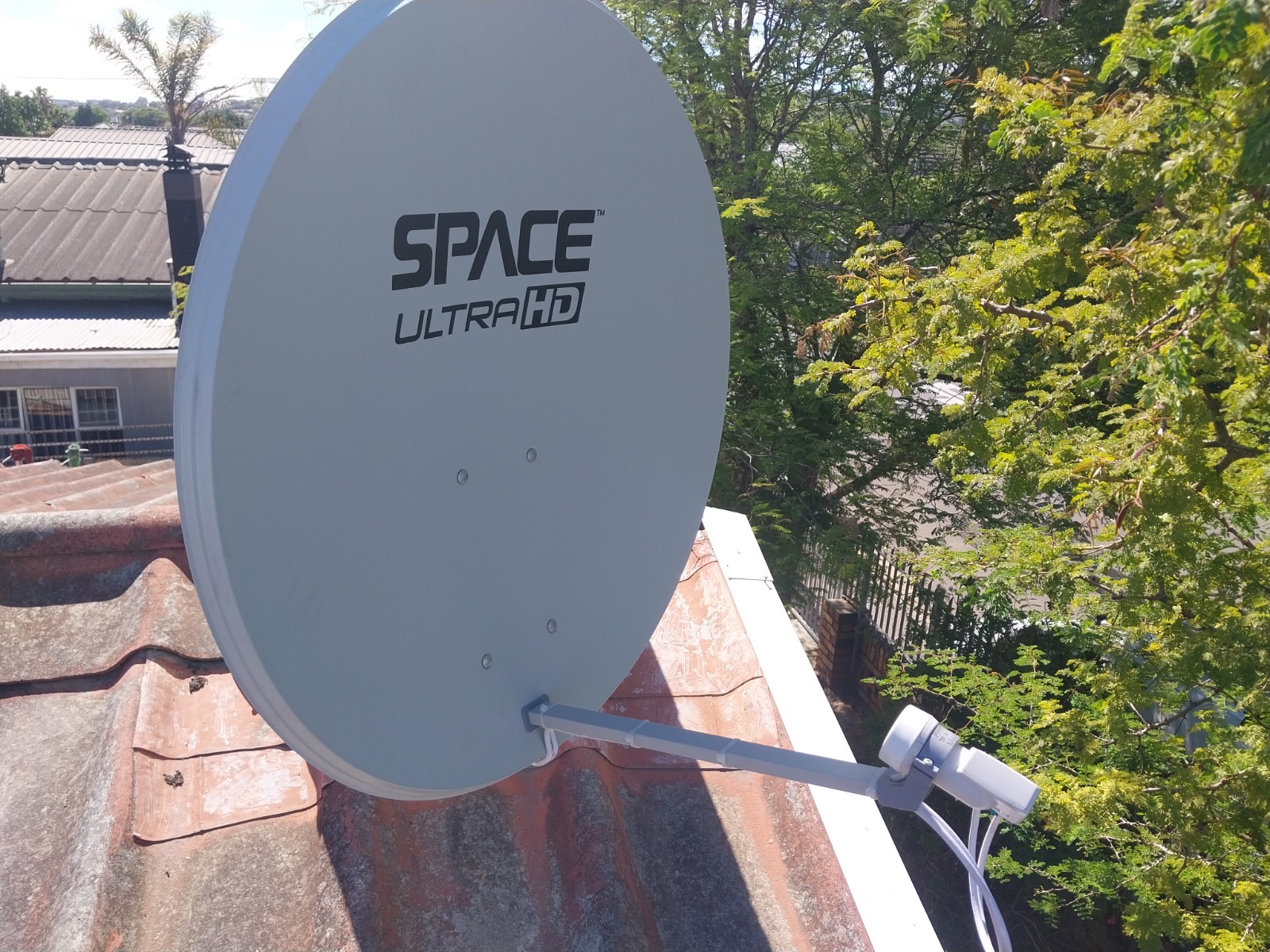 Space UltraHD satellite dish mounted on a tile roof